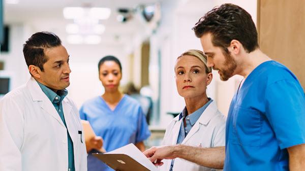 Clinicians talk in the hallway of a hospital